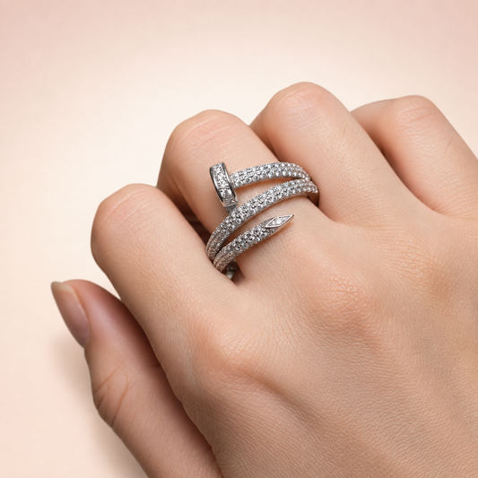 Anillo de Plata 925 Forma de Clavo Doble Vuelta sobre fondo rosa nude, blanco y beige