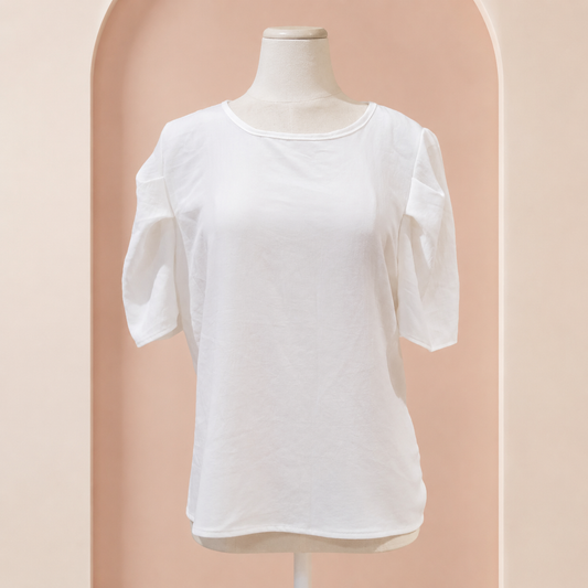 Blusa de vestir blanca con botón atrás en fondo rosa nude, blanco y beige