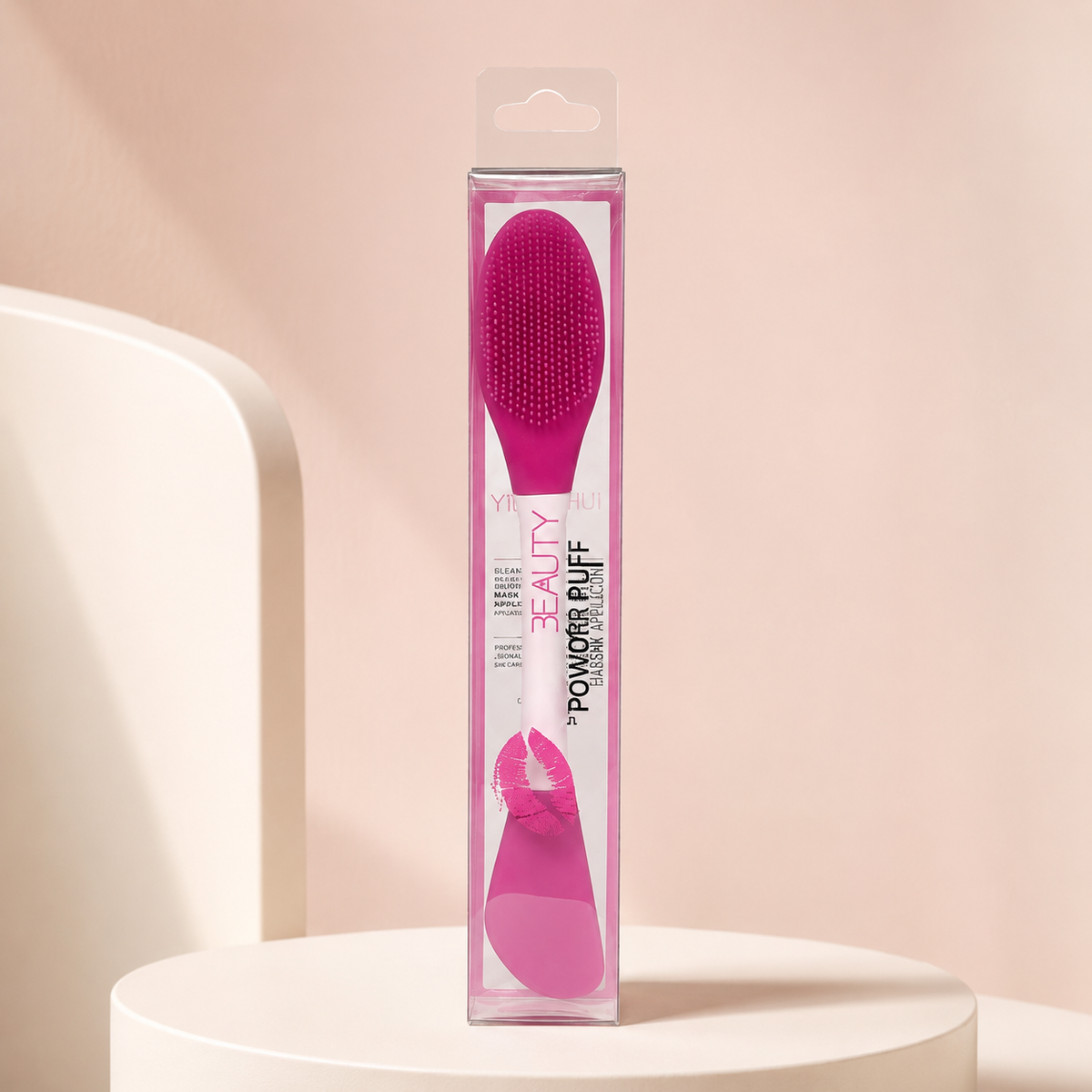 Espátula y cepillo limpiador HUDA rosa intenso en empaque sobre fondo rosa nude, blanco y beige
