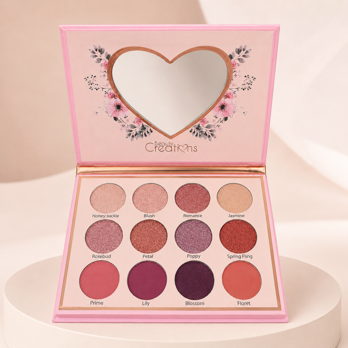 Paleta Eye Bloom de Beauty Creations abierta sobre fondo rosa nude, blanco y beige
