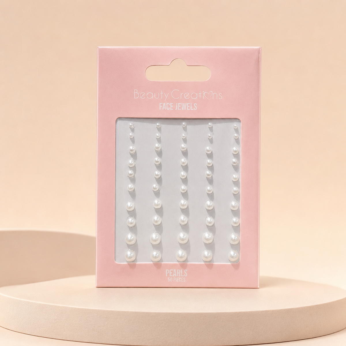 Face Jewels Pearls de Beauty Creations sobre fondo rosa nude, blanco y beige