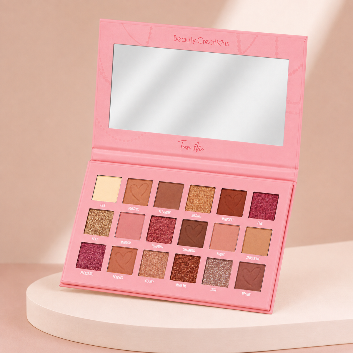 Paleta Tease Me de Beauty Creations abierta en vista angular sobre fondo rosa nude, blanco y beige